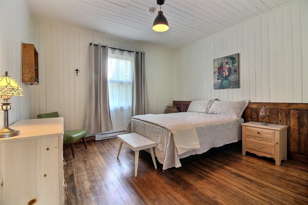 La chambre Price : lit double, tête de lit en bois ancien, fenêtre sur l'extérieur.