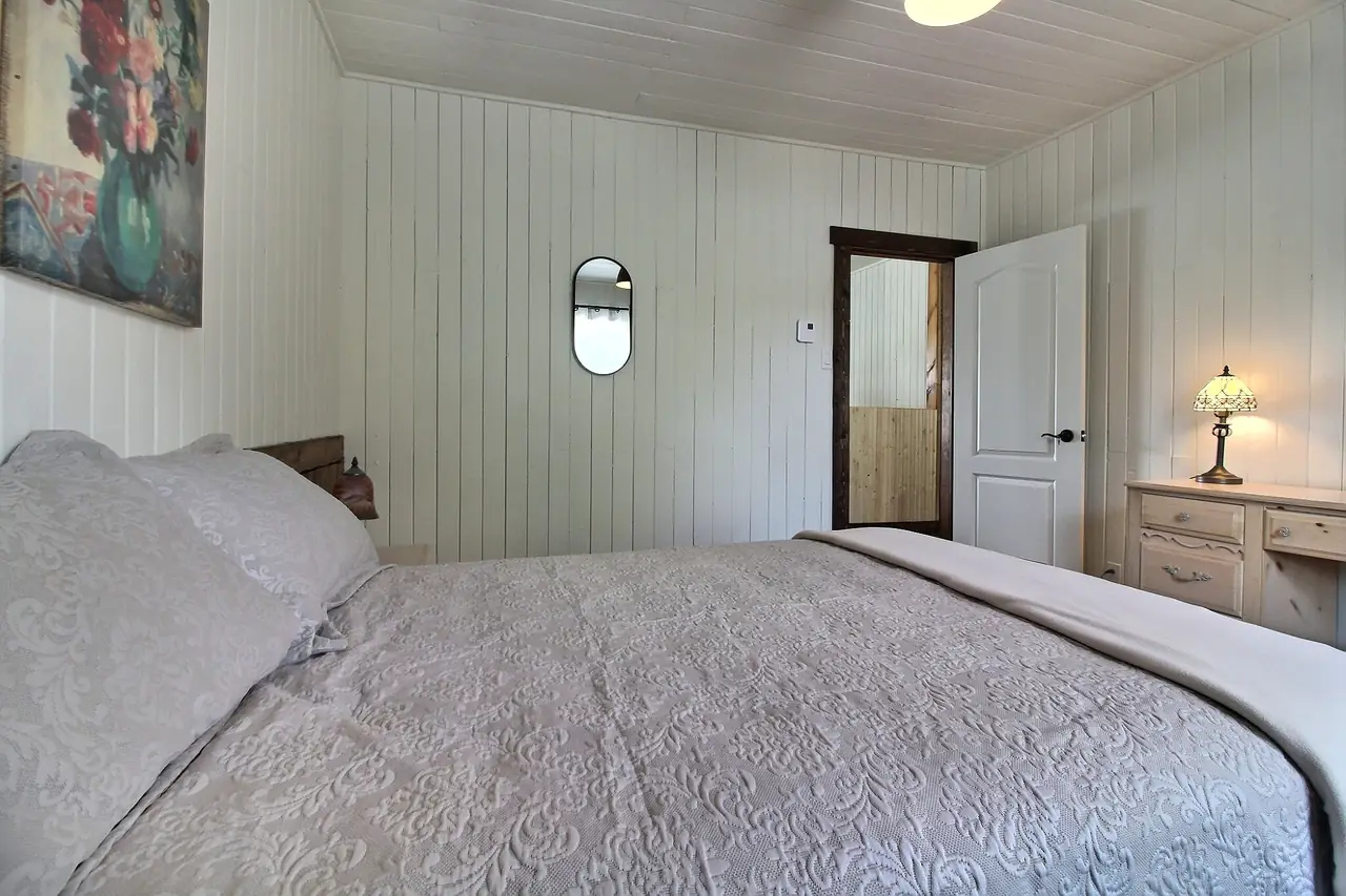 La chambre Price vue de l'autre côté : miroir, commode et porte sur le couloir.