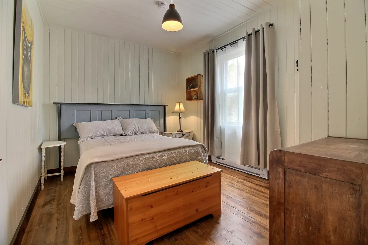 La chambre M. R. Kane : lit double, tête de lit faite d'une ancienne porte peinte.